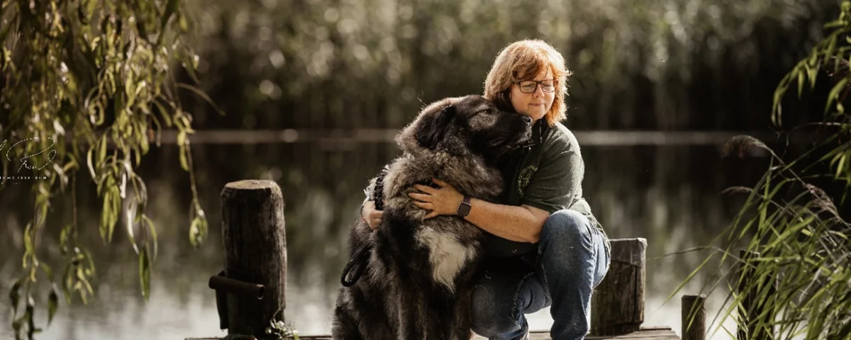 Tanja Sievers, Tierheilpraktikerin, mit Hund am Wasser an der Eider